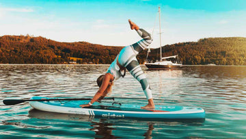 Woman on Paddle Board in sea practicing Yoga