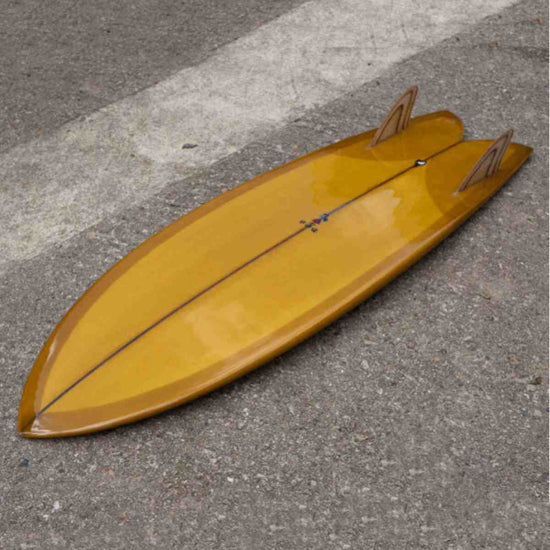 BOS Trad Fish Surfboard 5ft 5 Gold Brown placed on floor with fins up