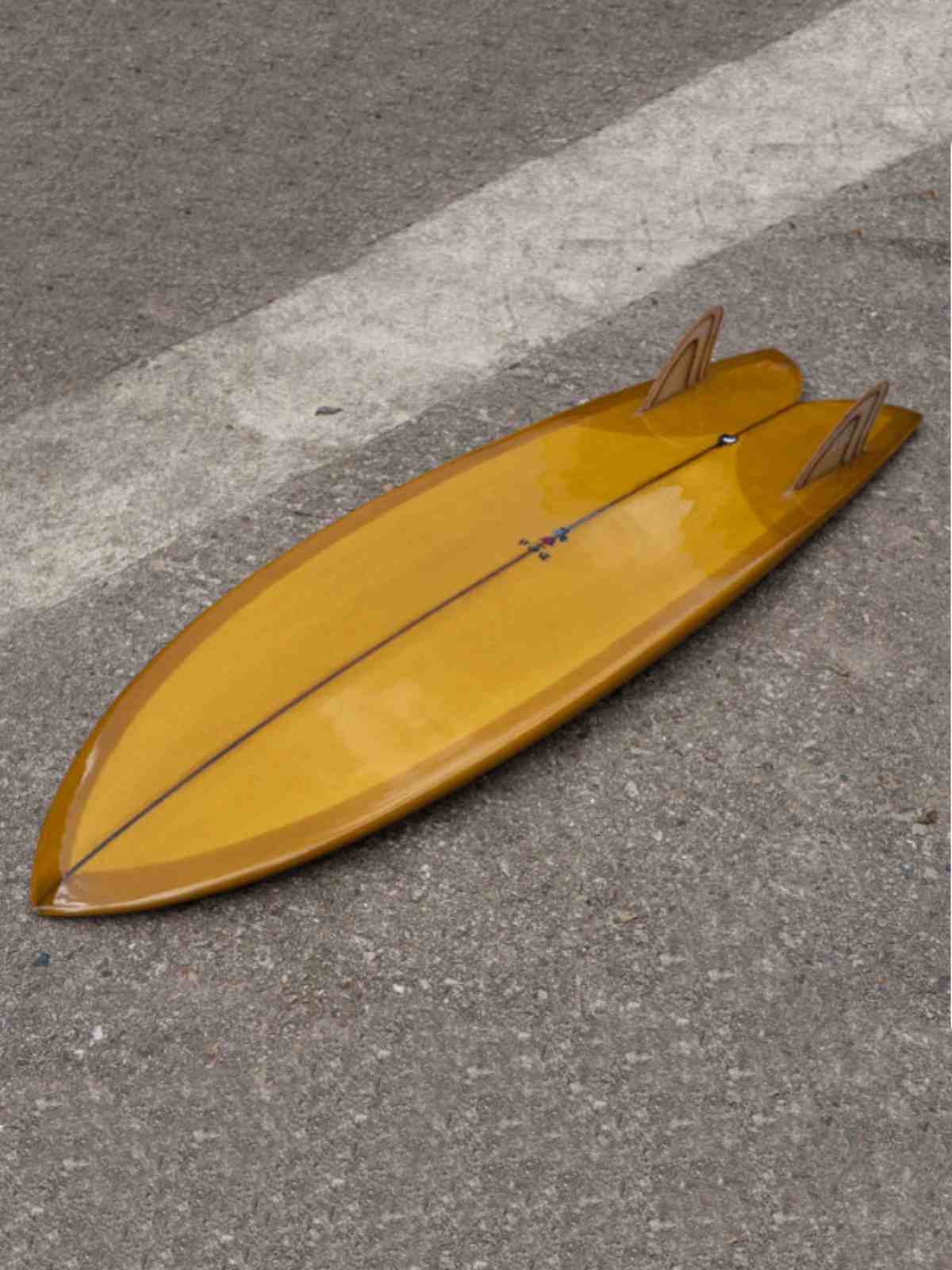 BOS Trad Fish Surfboard 5ft 5 Gold Brown placed on floor with fins up